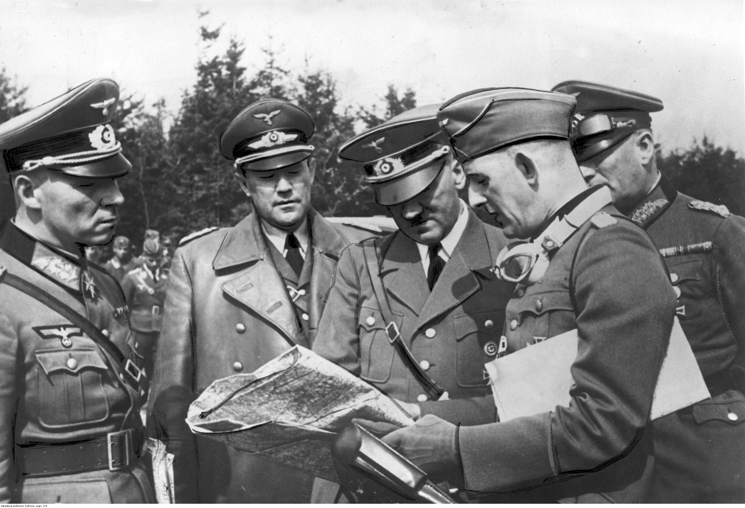 Adolf Hitler reviews strategic maps of the Poland campaign with his generals